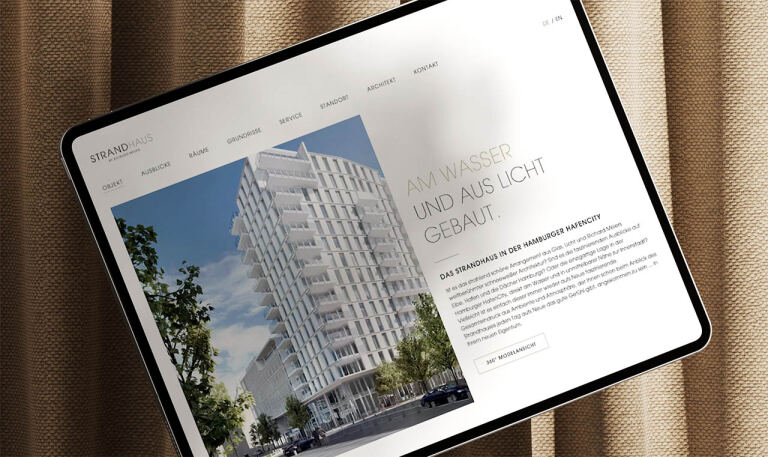 Rendering eines modernen mehrgeschossigen Wohngebäudes – auf einem Tabletbildschirm angezeigt. Kontext: Straßenfront mit Bäumen und Autos, Website-Layout mit Navigation und Text. Sichtbarer Text: 