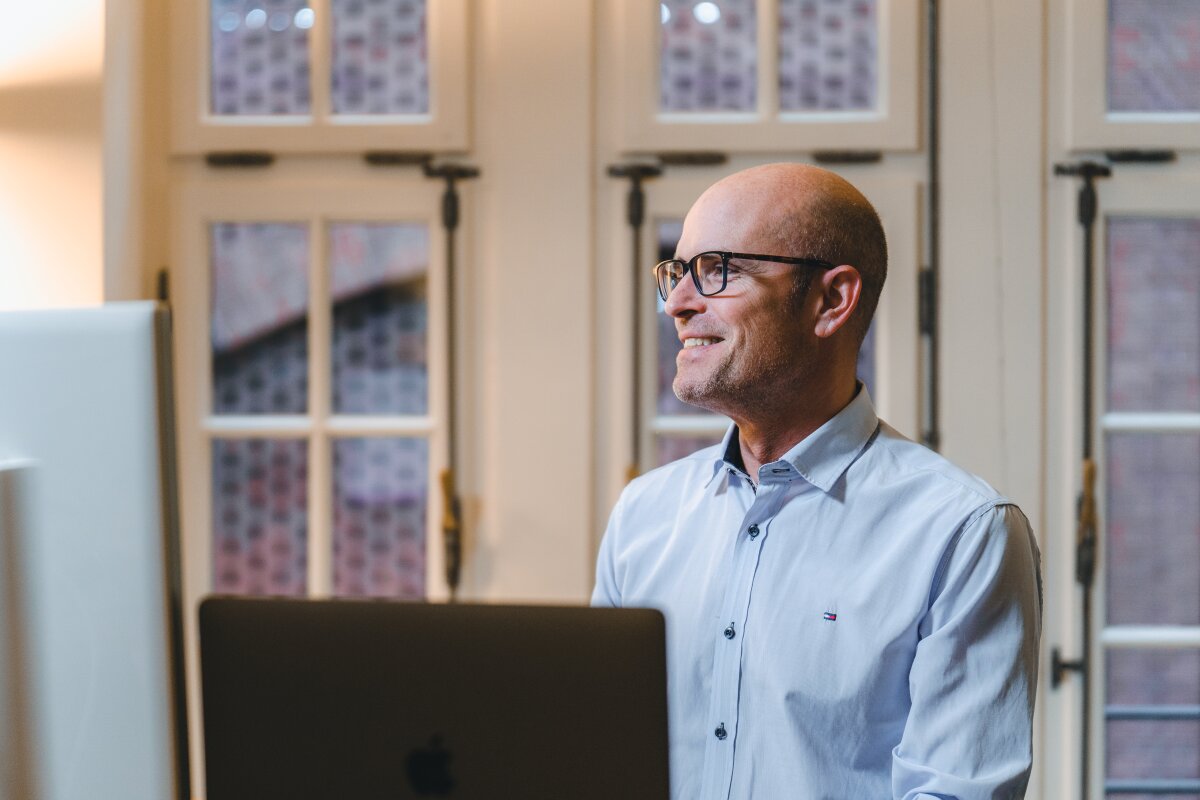 Mitarbeiter von Homepage Helden mit Brille arbeitet konzentriert am Laptop.